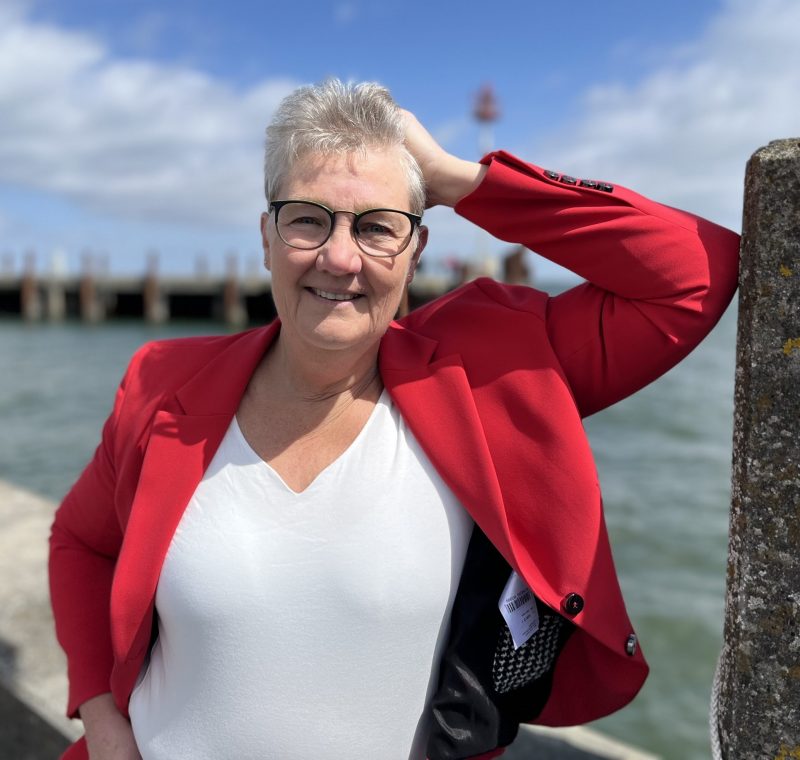 Margot mit Wasser an Mauer gelehntAusschnitt Margot Böhm am Hafen List angelehnt mit Blick auf die Nordmole